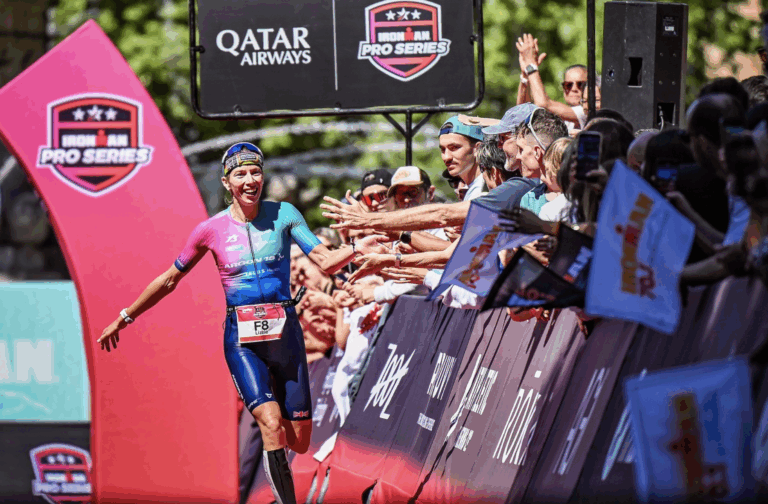 Lizzie Rayner running down the finish line high fiving the crowd at IRONMAN 70.3 Pays d'Aix Photo Credit: IRONMAN