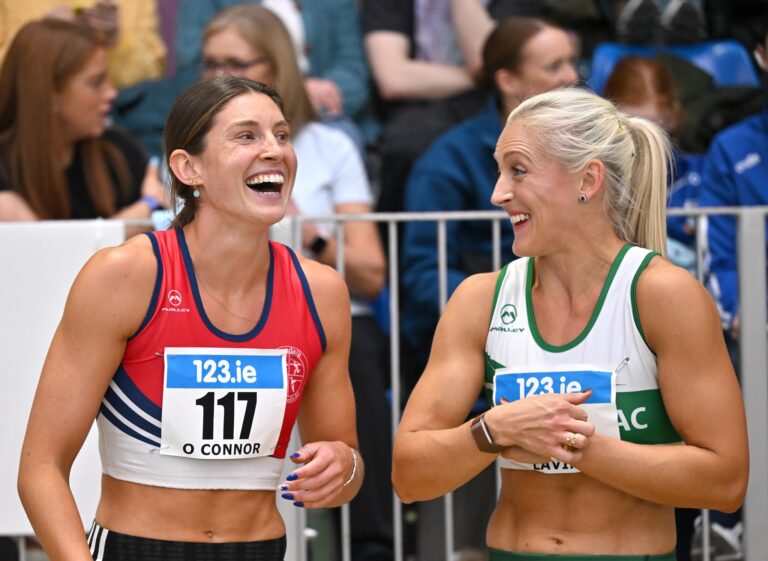 28 February 2026; Kate O'Connor of Dundalk St Gerards AC, Louth, left, and Sarah Lavin of Emerald AC, Limerick, share a joke after competing in the women's 60m hurdles during day one of the 123.ie National Senior Indoor Championships at the National Indoor Arena on the Sport Ireland Campus in Dublin. Photo by Sam Barnes/Sportsfile